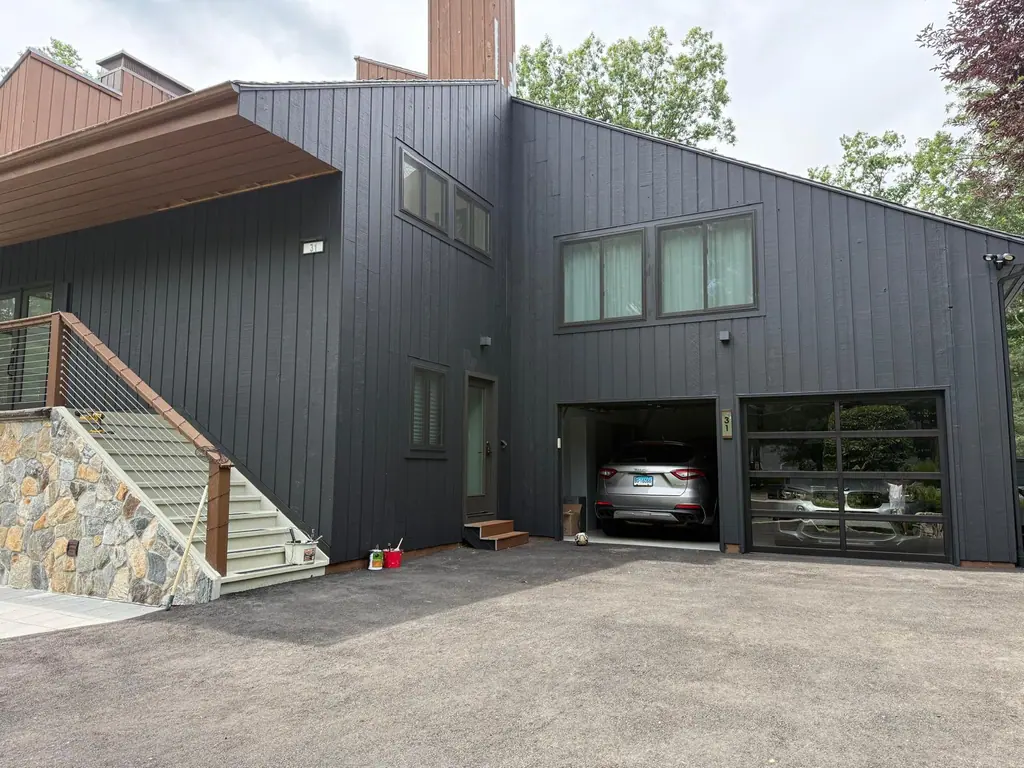 The same contemporary home after its siding was painted black