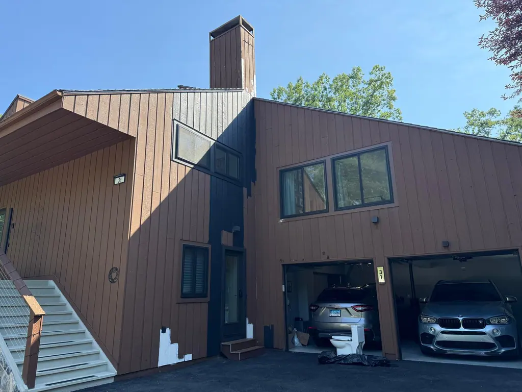 Contemporary home with brown vertical siding before painting