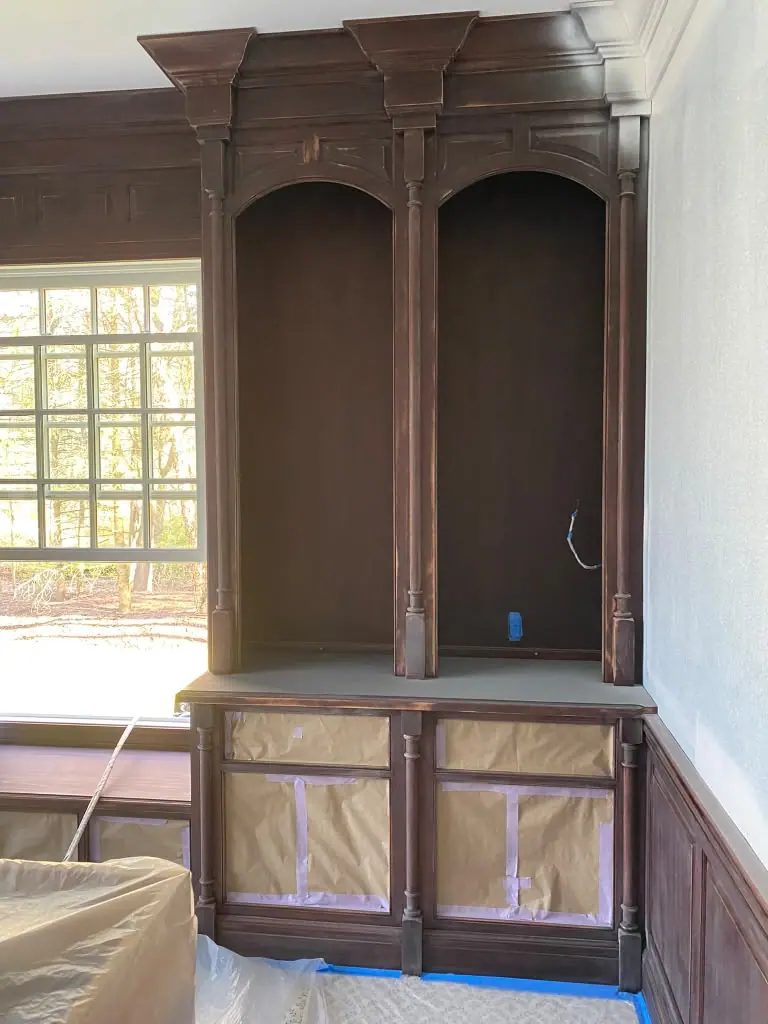 Cherry wood library built-ins with arched bookcases before painting