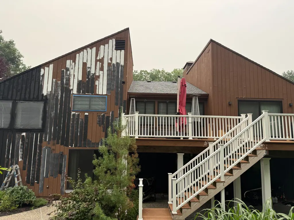 Back of a home with worn, peeling siding before painting